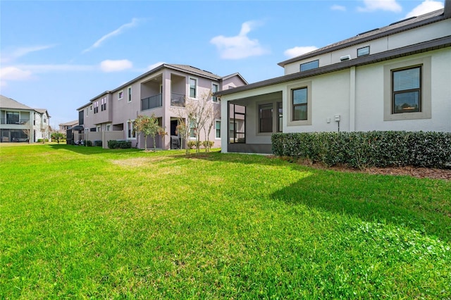 view of front of house featuring a front lawn, a residential view, and stucco siding