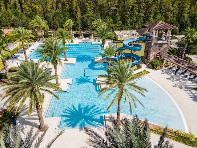 community pool featuring a patio area and a water slide