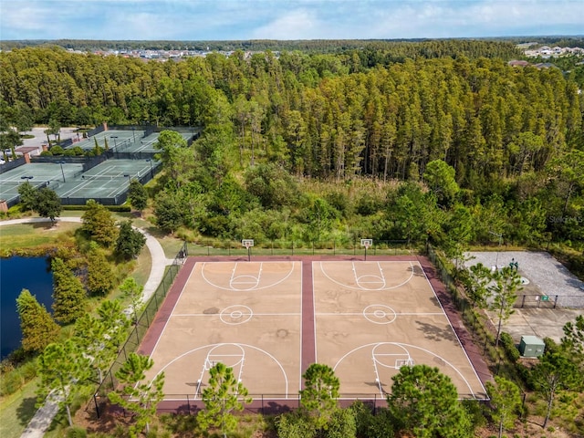 view of sport court with a forest view, a water view, and community basketball court