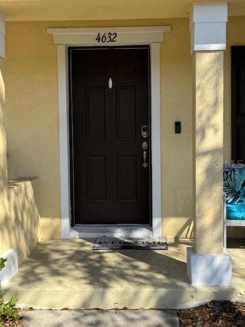 doorway to property featuring stucco siding