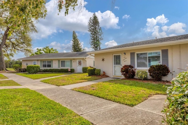 single story home with stucco siding and a front lawn