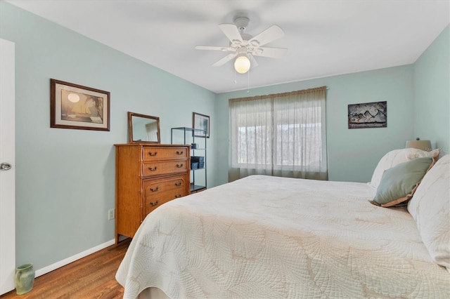 bedroom with ceiling fan, baseboards, and wood finished floors