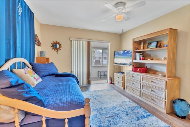 bedroom featuring access to outside, a ceiling fan, and wood finished floors