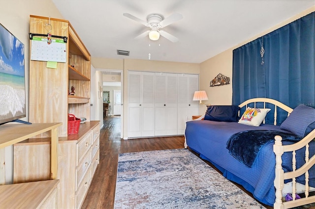 bedroom featuring visible vents, dark wood-type flooring, a closet, and a ceiling fan