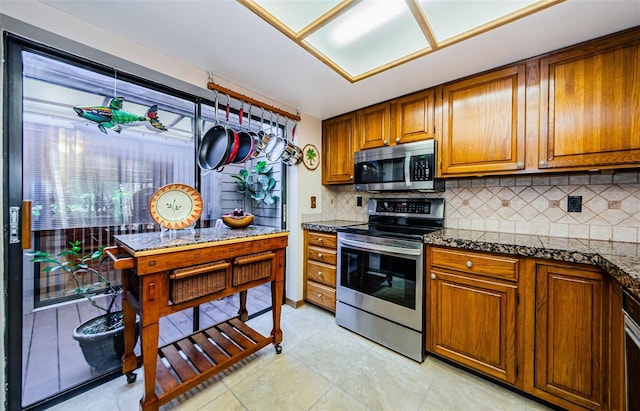 kitchen featuring appliances with stainless steel finishes, brown cabinetry, and decorative backsplash