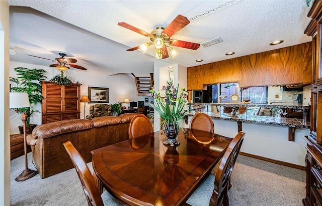 dining space with a textured ceiling, ceiling fan, recessed lighting, light colored carpet, and visible vents