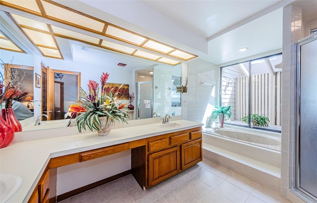 full bath featuring a stall shower, a garden tub, vanity, and tile patterned floors