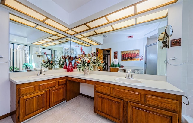 full bathroom featuring double vanity, a shower, and a sink