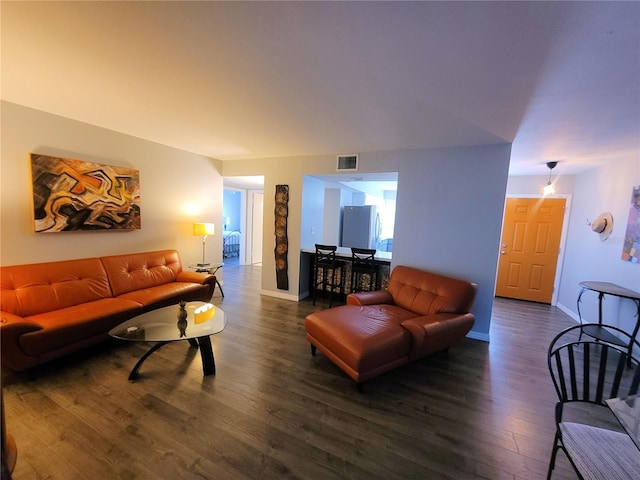 living area featuring dark wood finished floors, visible vents, and baseboards