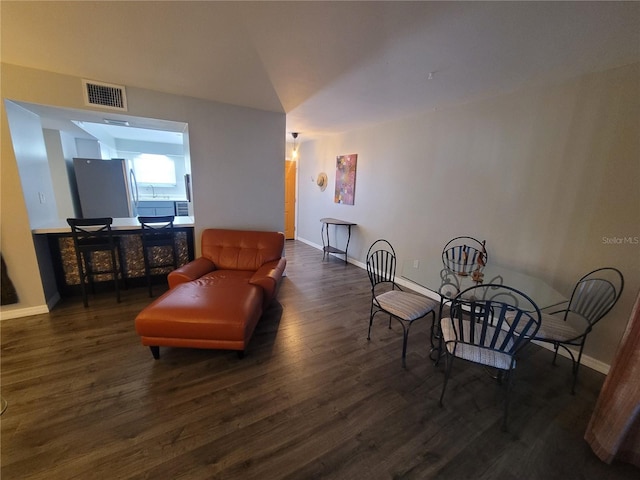 living area with visible vents, baseboards, and wood finished floors