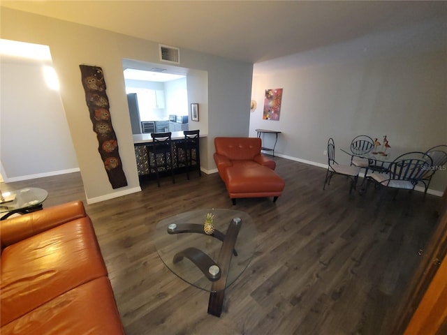 living area featuring visible vents, baseboards, and wood finished floors