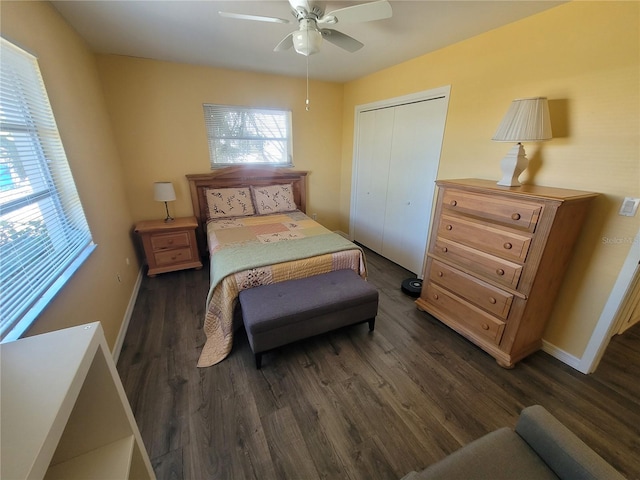 bedroom with a closet, dark wood finished floors, baseboards, and ceiling fan