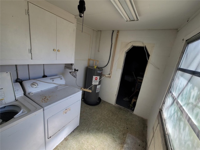 clothes washing area featuring washer and dryer, water heater, and cabinet space