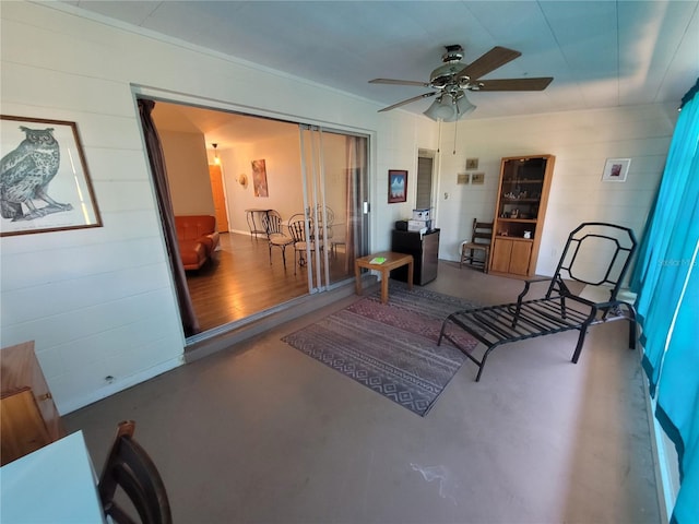 sitting room with ceiling fan and finished concrete floors