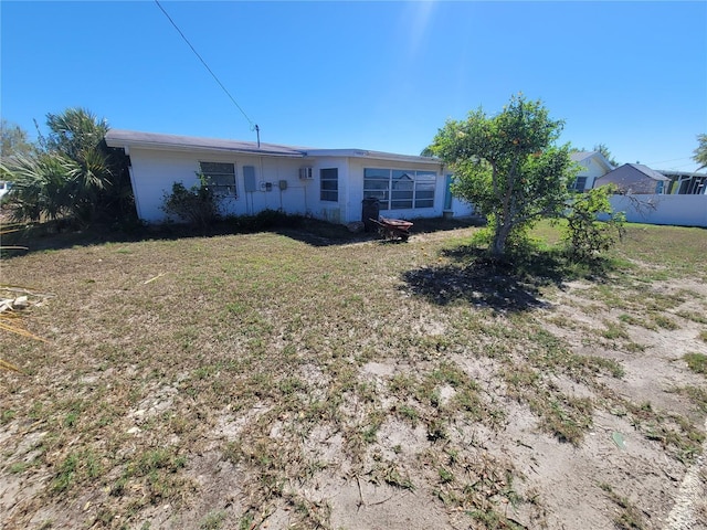 rear view of property with a yard and fence