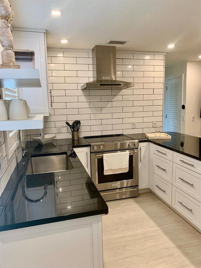 kitchen featuring stainless steel range with electric stovetop, dark countertops, open shelves, and extractor fan