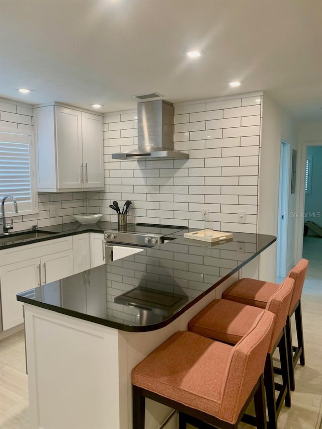 kitchen with a sink, electric stove, ventilation hood, backsplash, and dark countertops