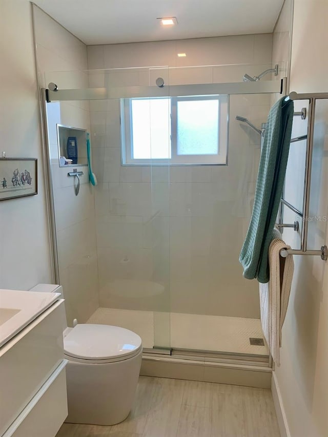 full bath with a stall shower, vanity, toilet, and wood finished floors