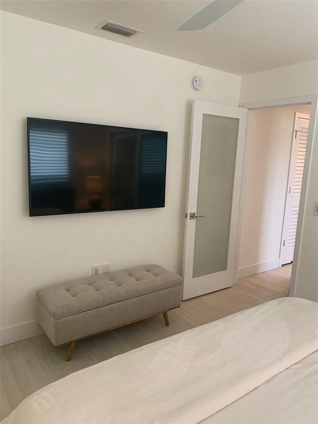 bedroom featuring wood finished floors, visible vents, and baseboards