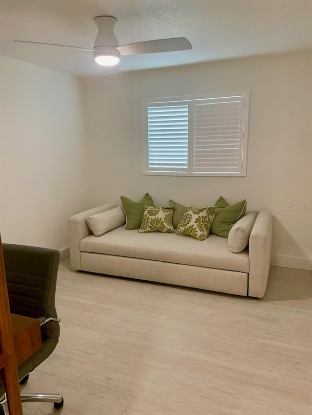 living room featuring light wood-style floors, ceiling fan, and baseboards