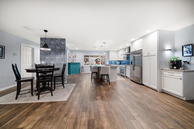 dining room featuring baseboards, visible vents, hardwood / wood-style floors, and recessed lighting