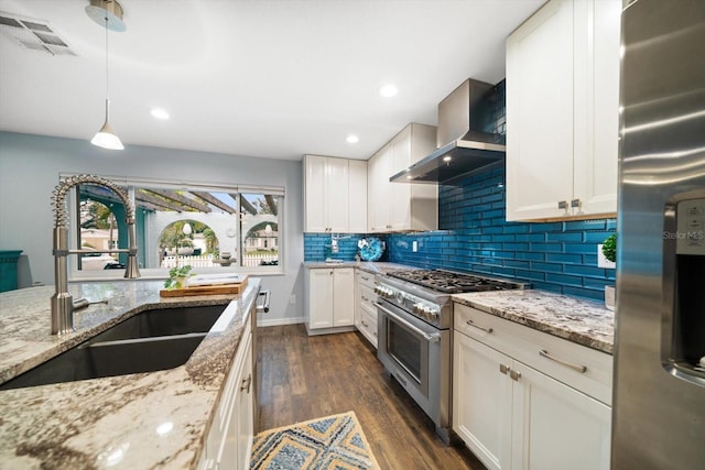 kitchen featuring visible vents, wall chimney exhaust hood, dark wood-type flooring, stainless steel appliances, and a sink