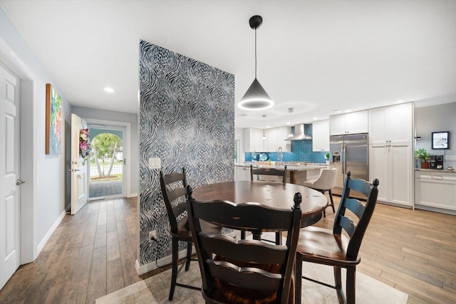 dining space with light wood-style floors, baseboards, and recessed lighting