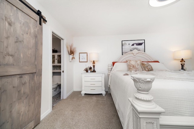 carpeted bedroom with a barn door and baseboards