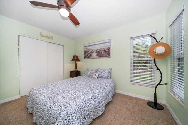 carpeted bedroom featuring a ceiling fan, baseboards, and a closet