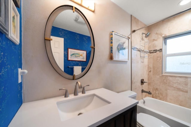 bathroom with toilet,  shower combination, and vanity