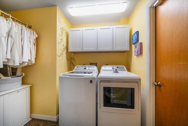 clothes washing area with cabinet space, baseboards, and washer and clothes dryer