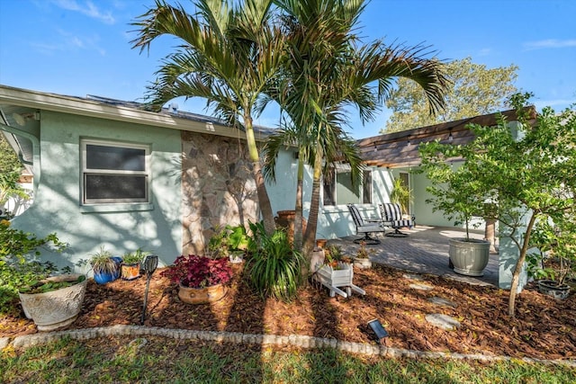 view of side of property with a patio and stucco siding