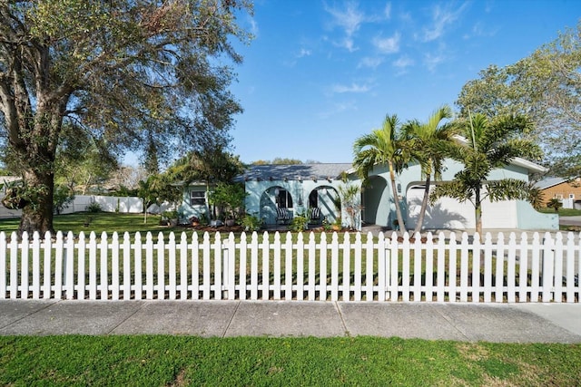 view of front of property featuring a fenced front yard, concrete driveway, and an attached garage