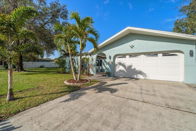 view of front of home with driveway, stucco siding, a garage, and a front yard