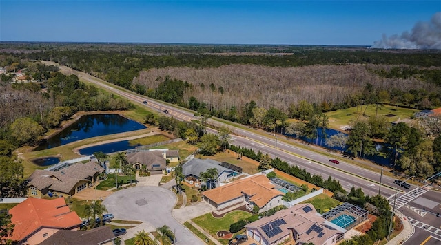 aerial view featuring a residential view, a wooded view, and a water view