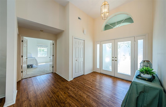 entrance foyer featuring visible vents, baseboards, dark wood finished floors, french doors, and a high ceiling