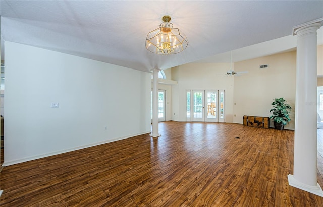 unfurnished living room with dark wood finished floors, french doors, baseboards, and ornate columns