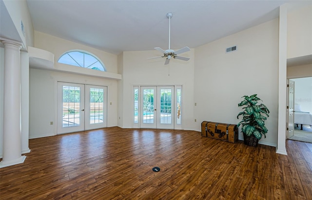 unfurnished living room with visible vents, french doors, hardwood / wood-style flooring, and decorative columns