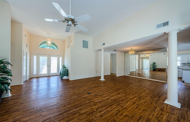 unfurnished living room featuring wood finished floors, decorative columns, french doors, and visible vents