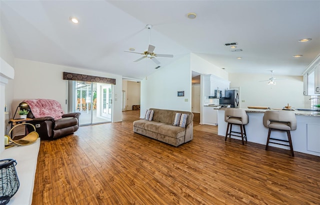 living area featuring a ceiling fan, vaulted ceiling, recessed lighting, and wood finished floors