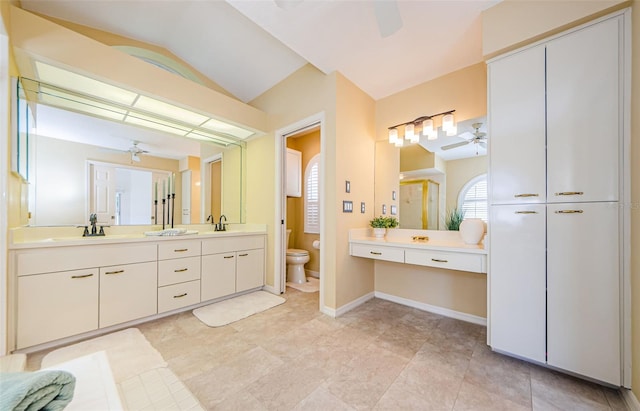 bathroom featuring toilet, lofted ceiling, ceiling fan, and a sink