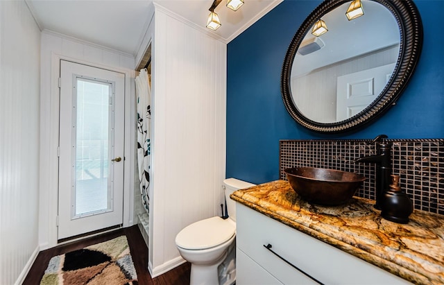 full bathroom featuring vanity, ornamental molding, a shower stall, toilet, and backsplash