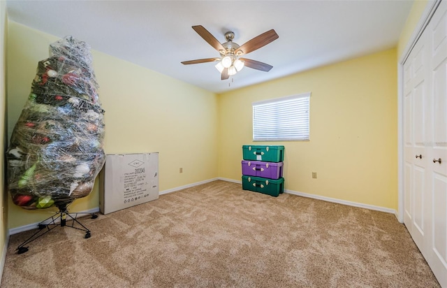 interior space with baseboards, carpet, and ceiling fan