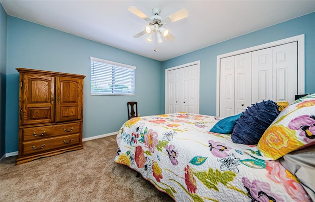 bedroom with a ceiling fan, carpet, multiple closets, and baseboards