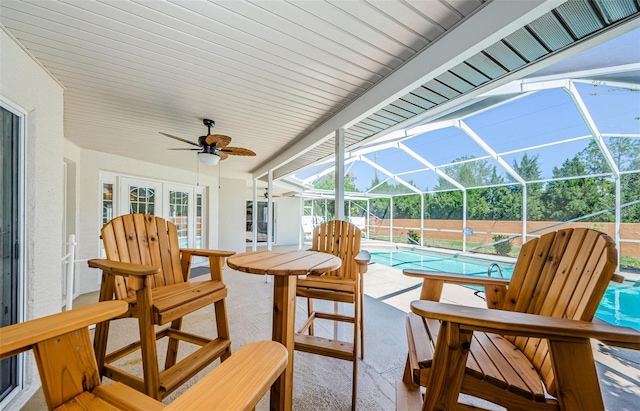 view of patio / terrace with a lanai, a ceiling fan, and a fenced in pool