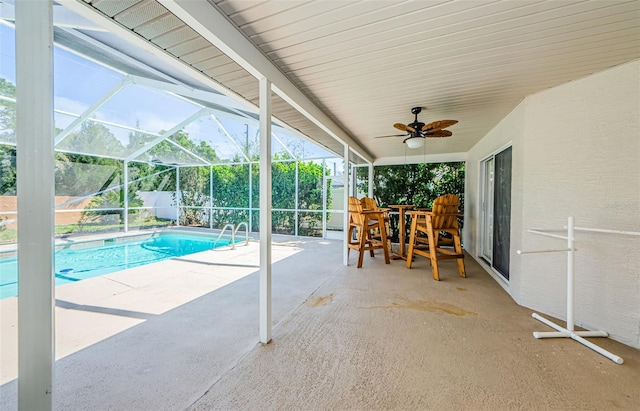 view of pool featuring a patio area, glass enclosure, ceiling fan, and a fenced in pool