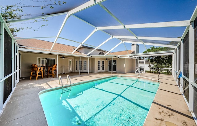 outdoor pool with glass enclosure, a patio area, french doors, and ceiling fan