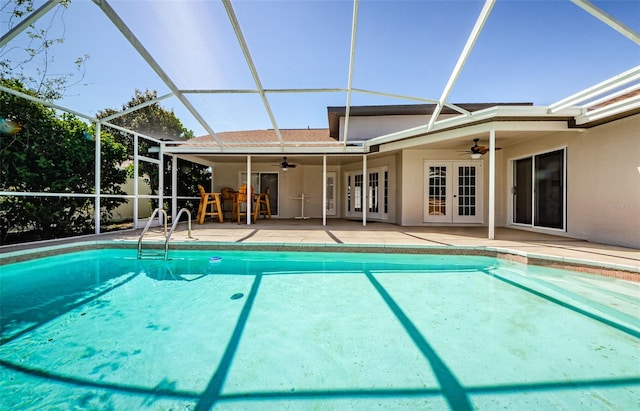 outdoor pool featuring glass enclosure, a patio area, french doors, and ceiling fan