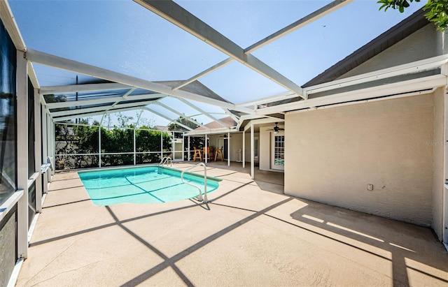 pool featuring glass enclosure, a patio, and ceiling fan