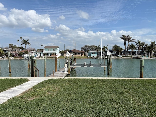 view of dock featuring a lawn, a water view, and boat lift